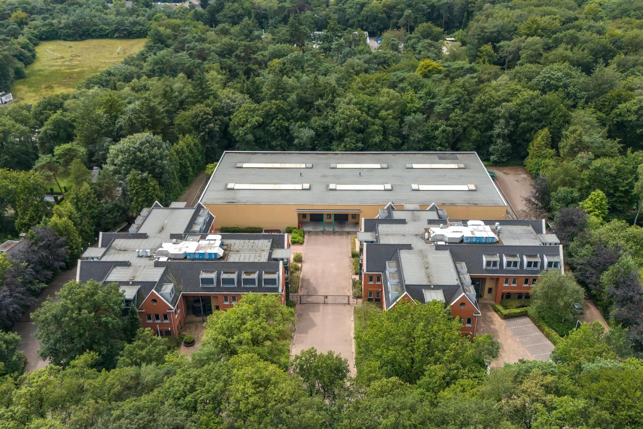 Luchtfoto van een groot gebouw aan de Laan Blussé van Oud-Alblas, omringd door bosrijk gebied.